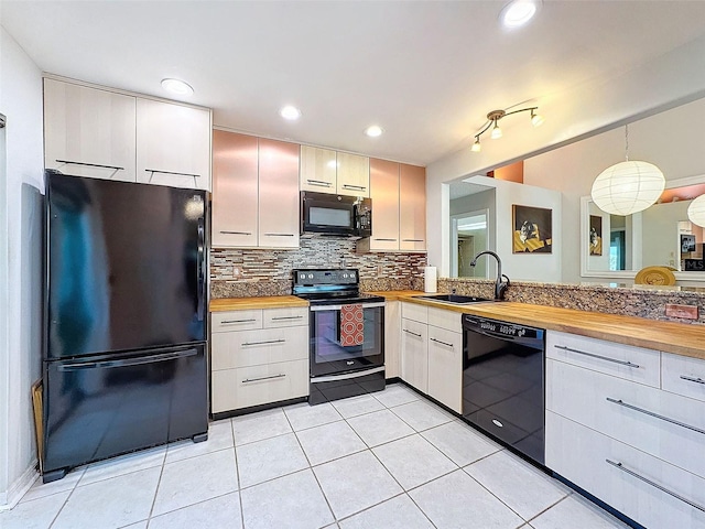 kitchen featuring sink, wooden counters, backsplash, pendant lighting, and black appliances