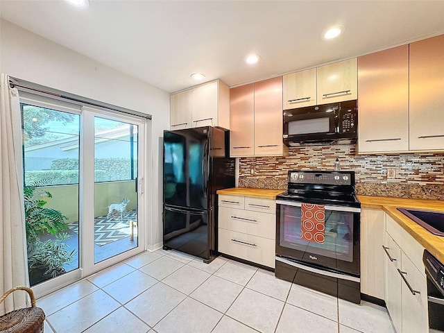 kitchen with wood counters, black appliances, sink, decorative backsplash, and light tile patterned floors