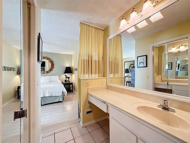 bathroom featuring tile patterned floors, vanity, and a textured ceiling