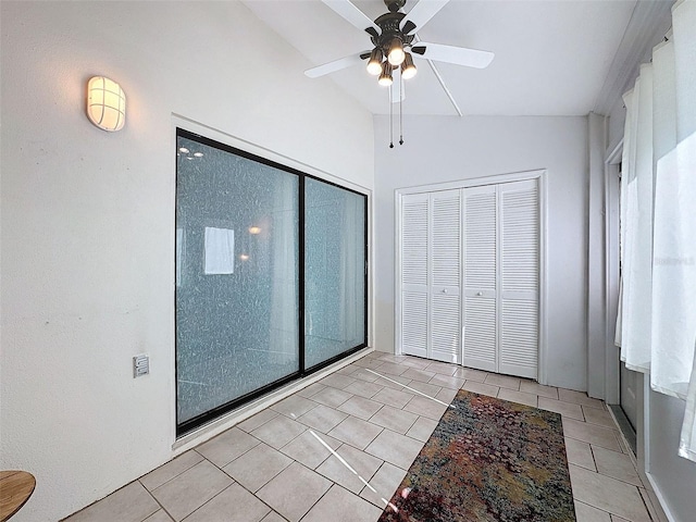 unfurnished bedroom with ceiling fan, vaulted ceiling, light tile patterned floors, and a closet