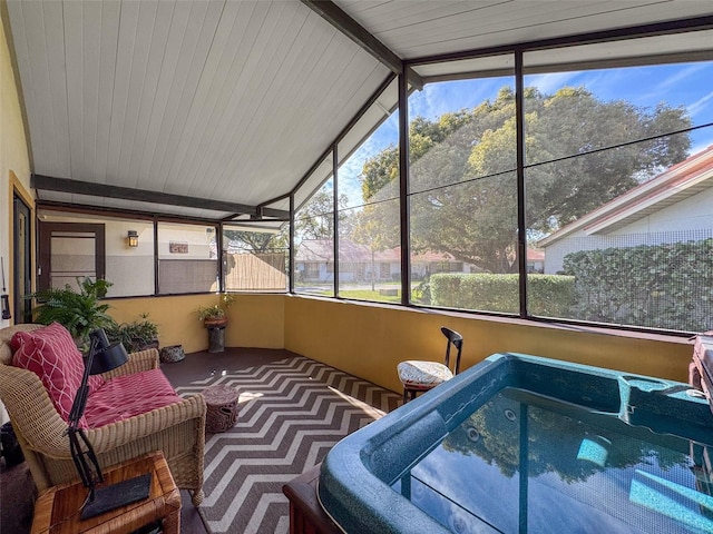 sunroom featuring vaulted ceiling with beams