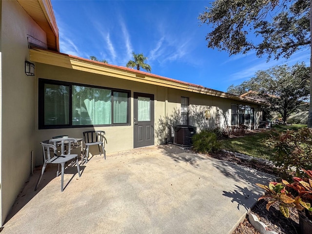 rear view of house featuring central AC unit and a patio area