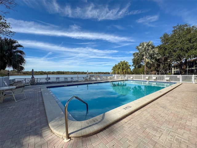 view of swimming pool with a water view and a patio