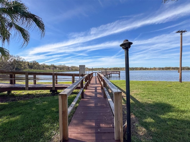 view of dock featuring a yard and a water view