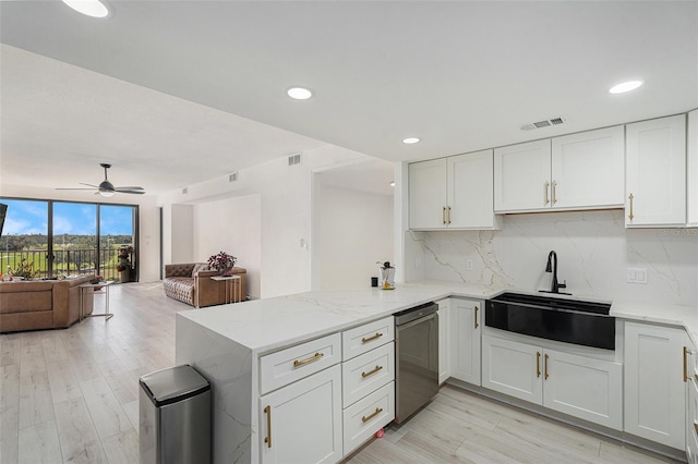 kitchen featuring backsplash, kitchen peninsula, sink, and white cabinets