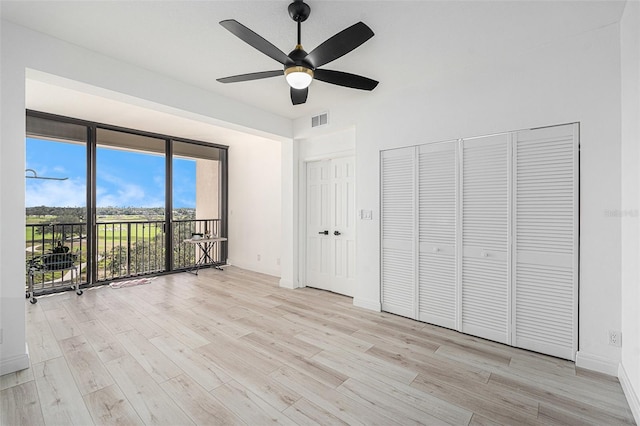 unfurnished bedroom featuring access to outside, ceiling fan, and light wood-type flooring