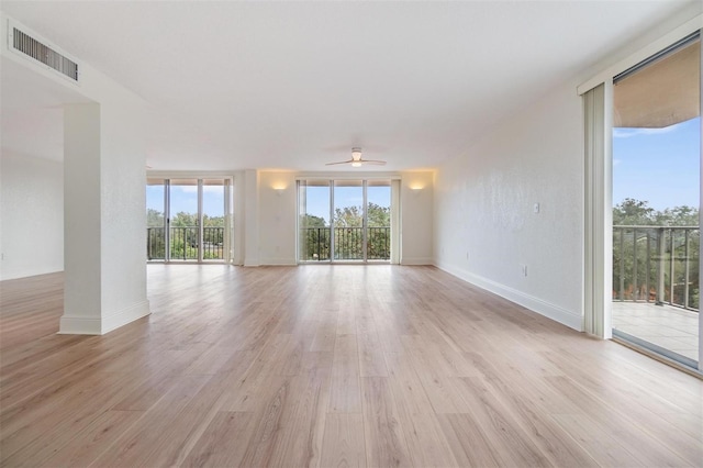 empty room with ceiling fan and light hardwood / wood-style flooring