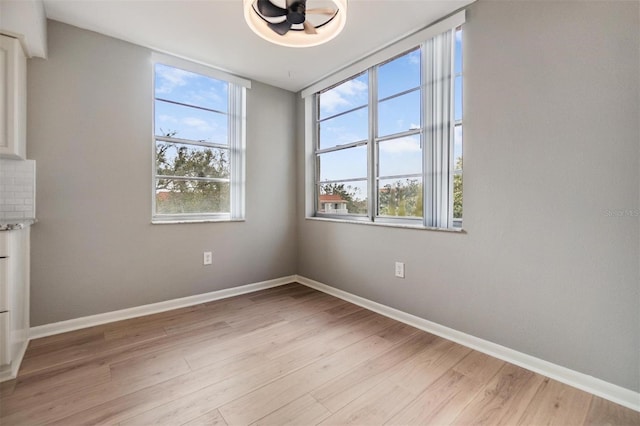 spare room with a healthy amount of sunlight and light hardwood / wood-style flooring