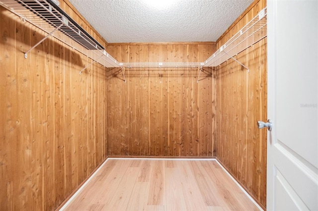 walk in closet with hardwood / wood-style flooring