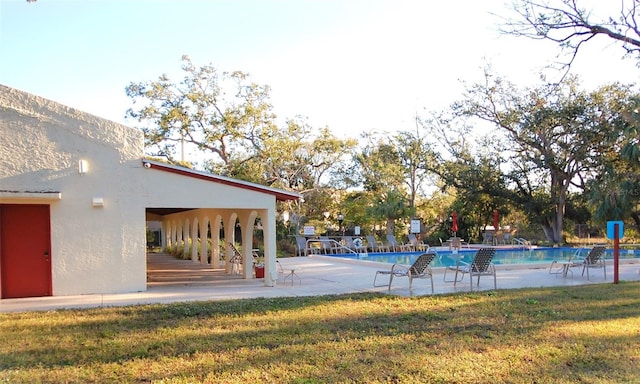 view of swimming pool featuring a patio area and a yard