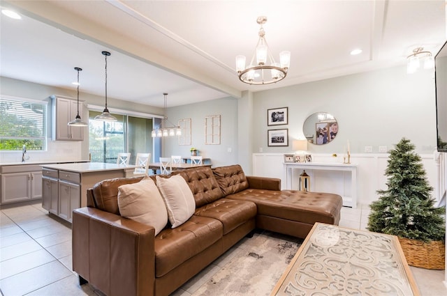 living room with sink, light tile patterned floors, and a notable chandelier