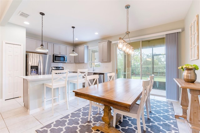 dining space with light tile patterned floors, a wealth of natural light, and sink