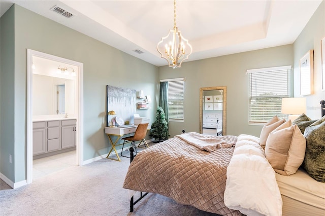 carpeted bedroom with a chandelier and a tray ceiling