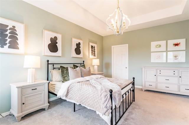 bedroom with a tray ceiling, light carpet, and a chandelier