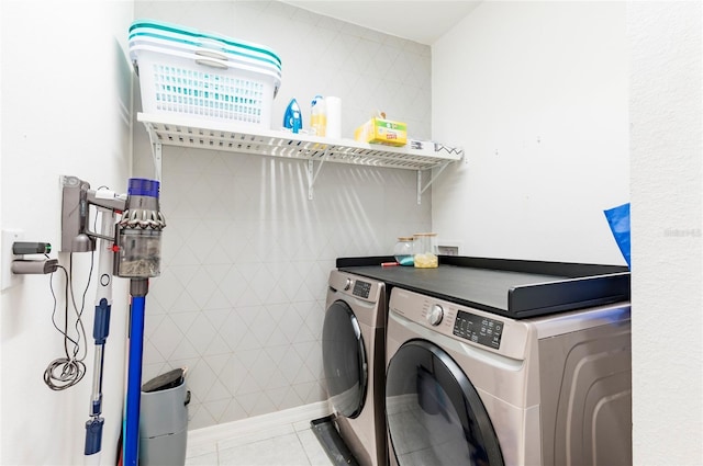 laundry area featuring washer and dryer and light tile patterned floors