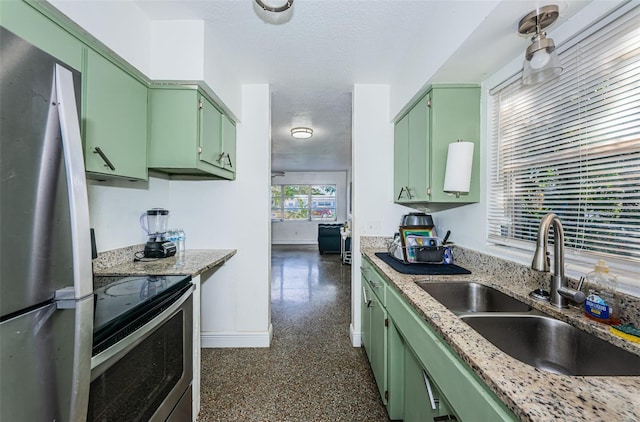 kitchen featuring sink, light stone countertops, stainless steel appliances, and green cabinetry