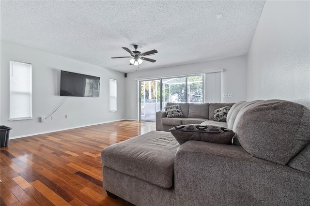 living room featuring a textured ceiling, ceiling fan, and dark hardwood / wood-style floors