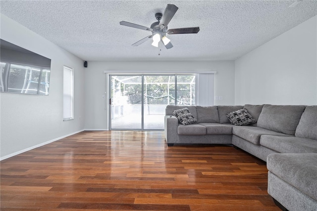 unfurnished living room featuring dark hardwood / wood-style floors, ceiling fan, and a textured ceiling