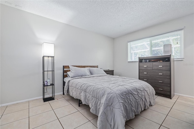 bedroom with light tile patterned flooring and a textured ceiling