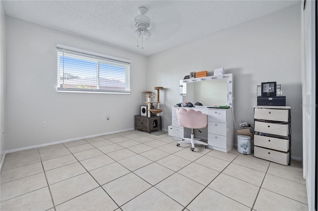 unfurnished office featuring ceiling fan, light tile patterned floors, and a textured ceiling