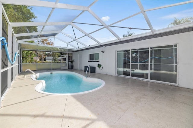 view of pool featuring glass enclosure and a patio