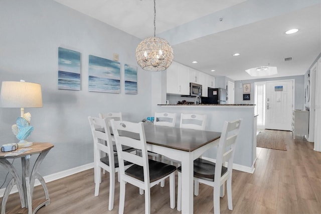 dining area featuring a chandelier and light hardwood / wood-style flooring