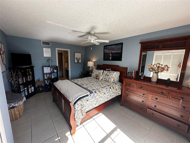 tiled bedroom featuring a textured ceiling and ceiling fan