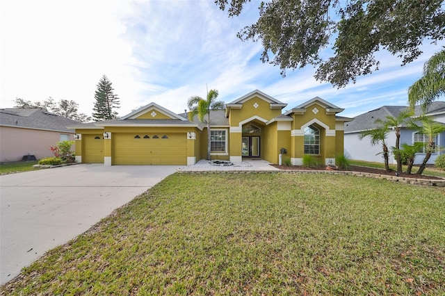 view of front of property featuring a garage, driveway, a front yard, and stucco siding