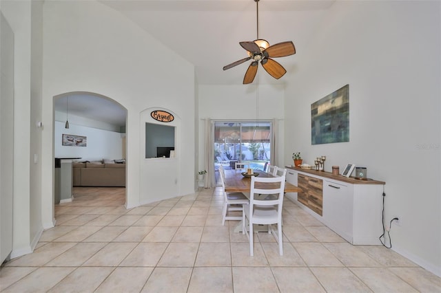 dining room featuring ceiling fan, a towering ceiling, and light tile patterned floors