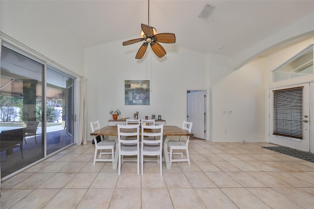 unfurnished dining area featuring ceiling fan, light tile patterned floors, and vaulted ceiling