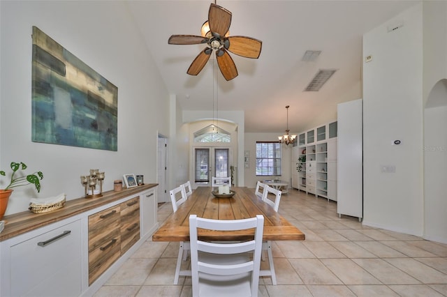 dining area with french doors, ceiling fan with notable chandelier, light tile patterned floors, and lofted ceiling