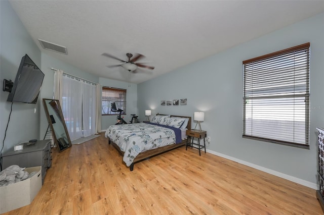 bedroom with a textured ceiling, light wood-type flooring, and ceiling fan