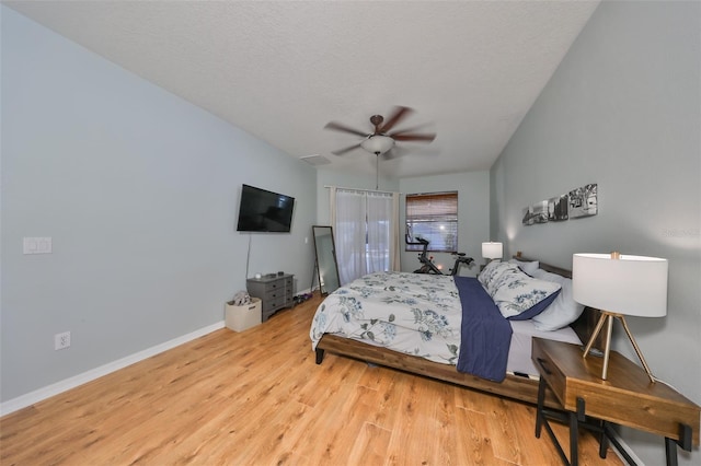 bedroom with ceiling fan, light hardwood / wood-style floors, and a textured ceiling