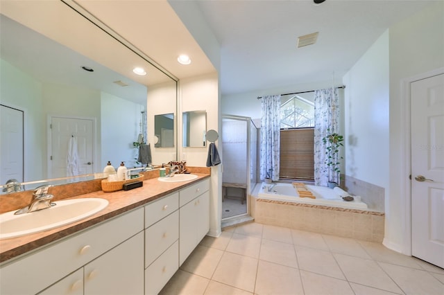 bathroom with tile patterned floors, vanity, and shower with separate bathtub