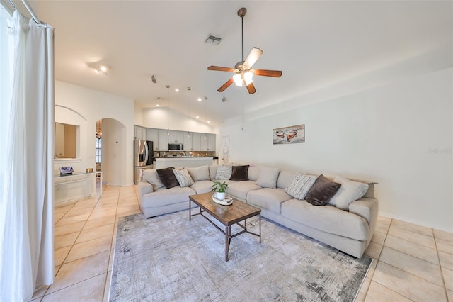 tiled living room with ceiling fan and lofted ceiling