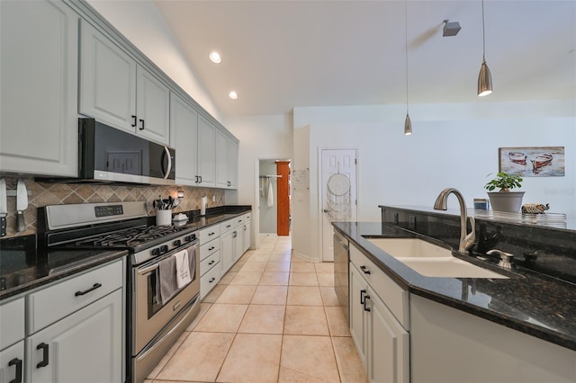 kitchen featuring decorative backsplash, stainless steel appliances, sink, light tile patterned floors, and hanging light fixtures