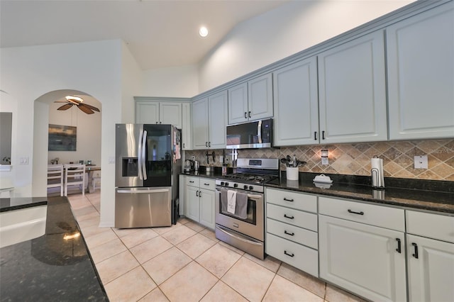 kitchen with decorative backsplash, appliances with stainless steel finishes, ceiling fan, light tile patterned floors, and high vaulted ceiling