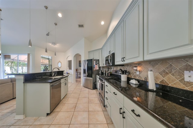 kitchen with backsplash, stainless steel appliances, vaulted ceiling, sink, and pendant lighting