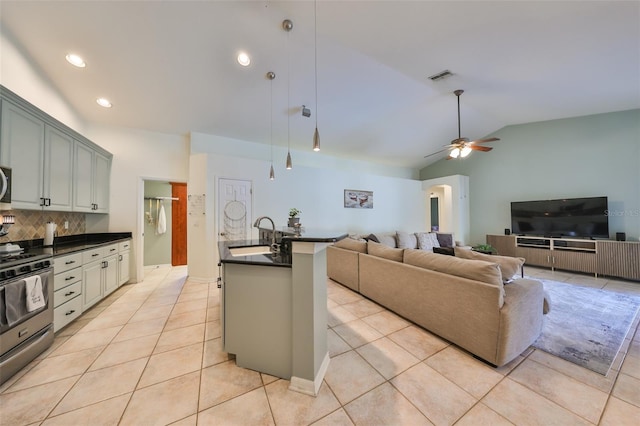 kitchen featuring lofted ceiling, sink, ceiling fan, stainless steel range, and tasteful backsplash