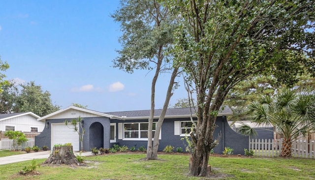 ranch-style home with an attached garage, driveway, fence, and a front yard