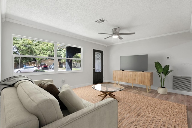 living room featuring visible vents, crown molding, and wood finished floors