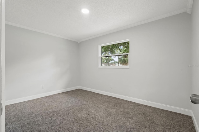 unfurnished room with a textured ceiling, carpet floors, ornamental molding, and baseboards