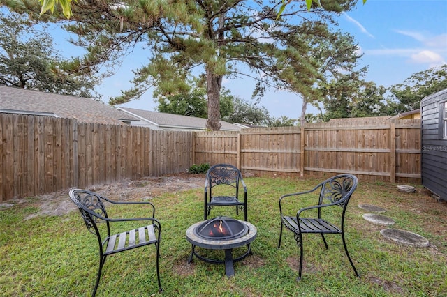 view of yard featuring a fire pit and a fenced backyard