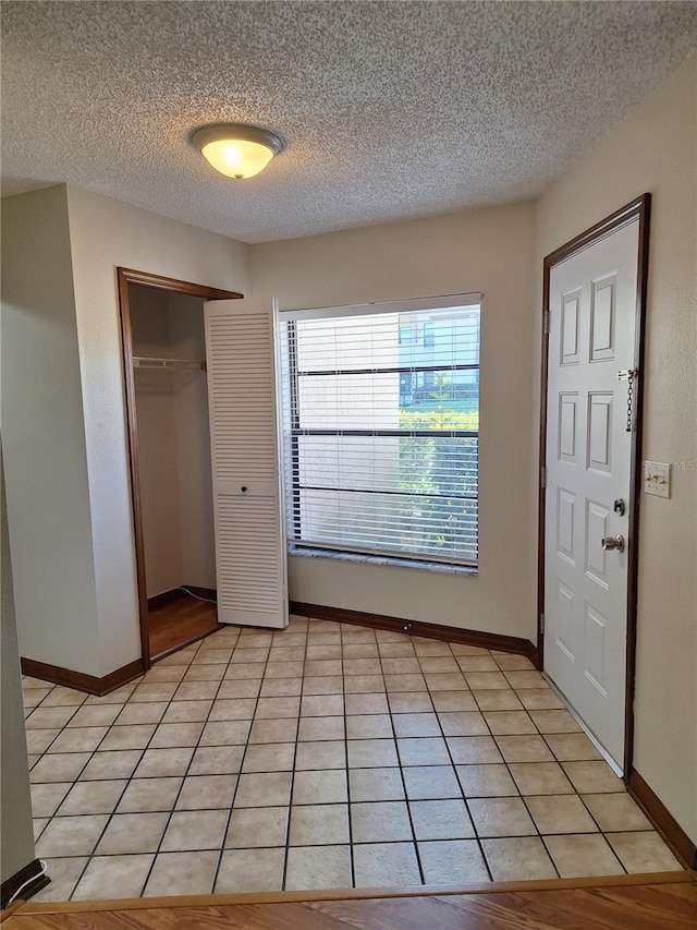 tiled entryway with a textured ceiling