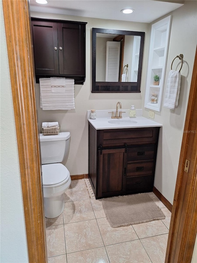 bathroom with tile patterned flooring, vanity, and toilet