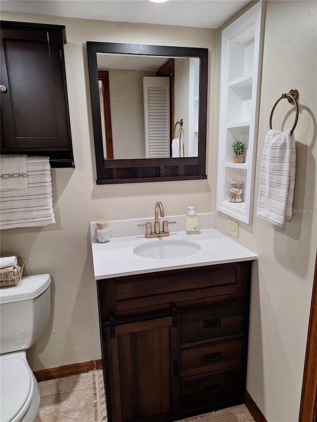 bathroom featuring built in features, vanity, and toilet