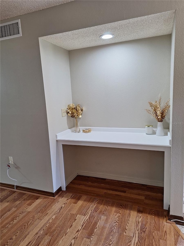 bathroom with hardwood / wood-style floors and a textured ceiling