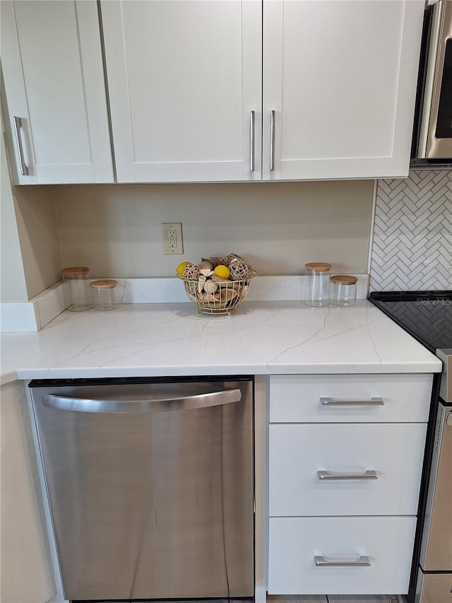 kitchen featuring light stone countertops, appliances with stainless steel finishes, and white cabinetry