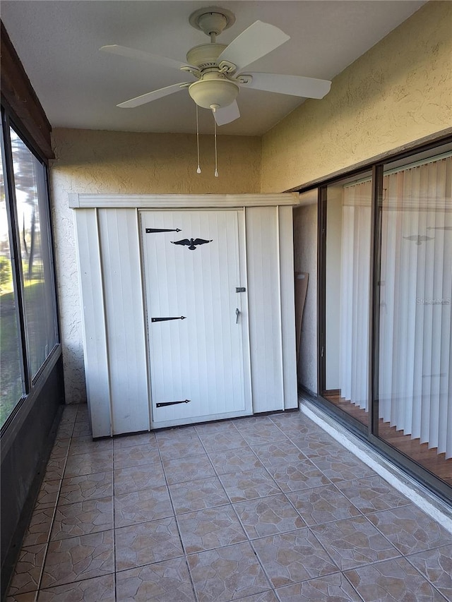 unfurnished sunroom with a wealth of natural light and ceiling fan