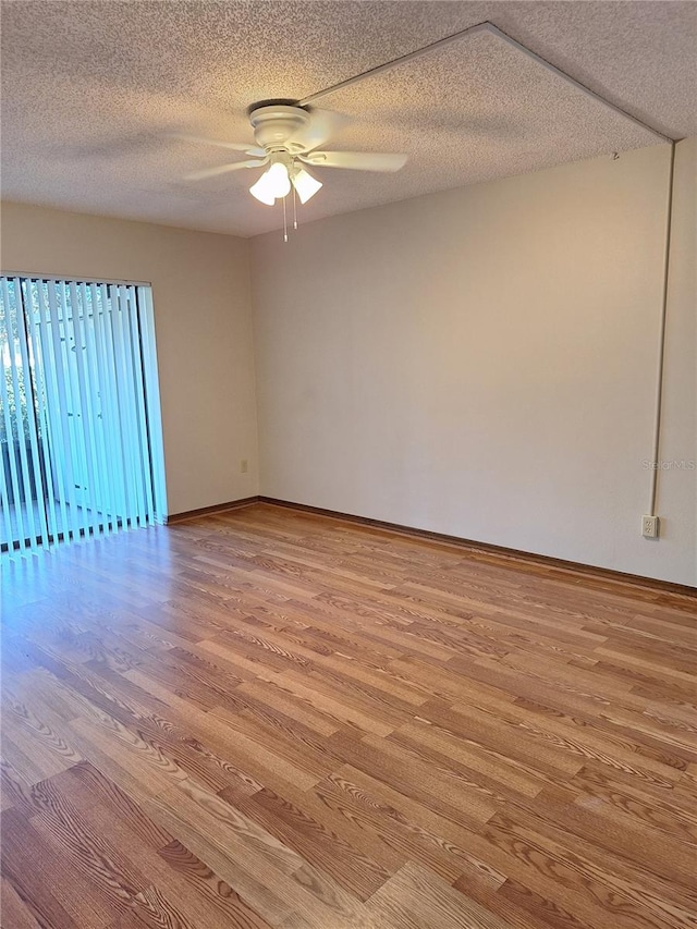 empty room featuring a textured ceiling, light hardwood / wood-style flooring, and ceiling fan